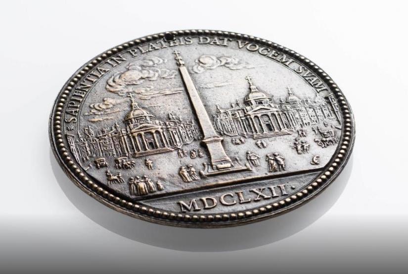 Eine Münze, auf der mehrere römische Gebäude abgebildet sind.