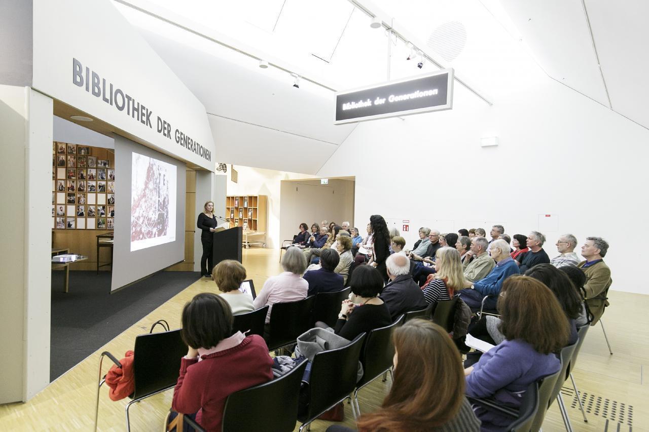 Ein Foto zeigt die Besucher*innen einer Lesung zur Ausstellung "Orte der Jugend".