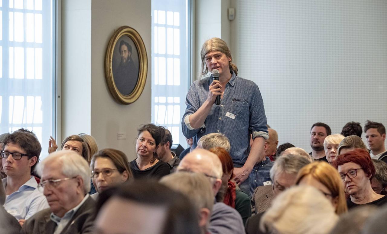 Das Foto zeigt Stefan Wiertz vom Förderverein Roma e.V., der aus dem Publikum eine Frage stellt.