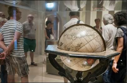 Das Foto zeigt einen Globus aus der Sammlung Waldschmidt und eine Gruppe darum herum